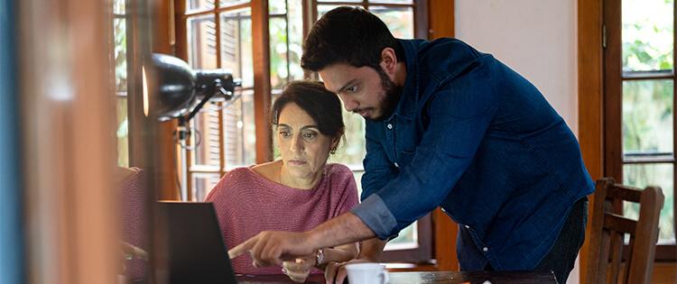 Un hombre y una mujer mirando una computadora portátil.
