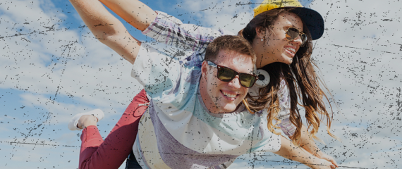 teenage girl on teenage boy's back with arms outstretched